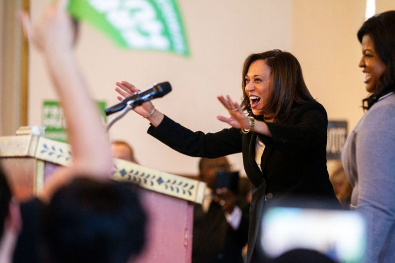 Sen. Kamala Harris, D-CA, waves to supporters while being welcomed on stage by Deidre DeJear during a \"All Hands on Deck\" event on Tuesday, Oct. 23, 2018, at Old Brick in Iowa City.