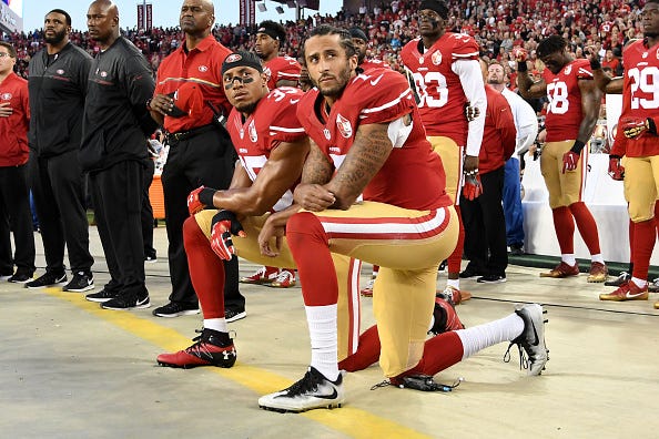 Colin Kaepernick kneels in protest during the national anthem.
