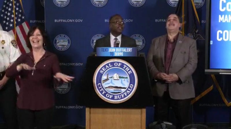 Karen Gambino (left) provides sign language interpreting during Mayor Byron Brown's March 17 press conference. In this moment, Mayor Brown encouraged Buffalonians to celebrate Tom Brady leaving New England. March 28, 2020 (Photo via Mayor Brown Facebook) 