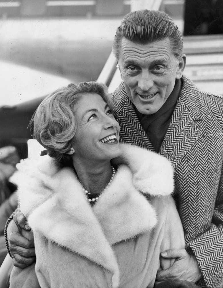 Kirk Douglas and his wife Anne Budyens arriving in London for the premiere of his new film, 'Spartacus' on Dec. 5, 1960 (Photo by Dennis Oulds/Central Press/Getty Images)