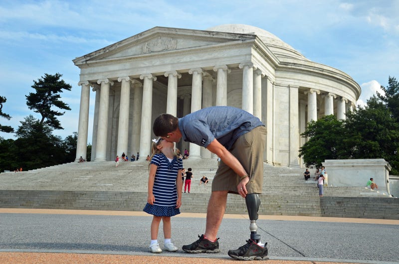 A wounded warrior and his daughter share a kiss in Washintong DC