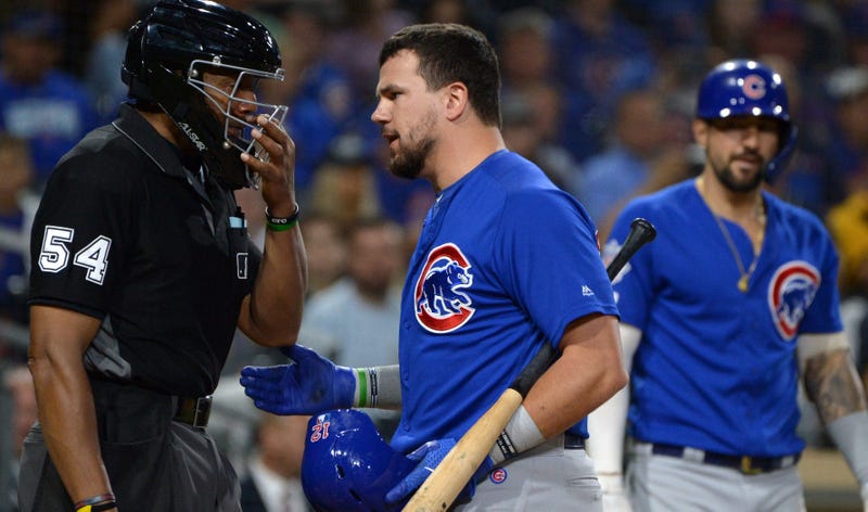 Cubs left fielder Kyle Schwarber (middle) talks to umpire CB Bucknor (54) after being called out on strikes.