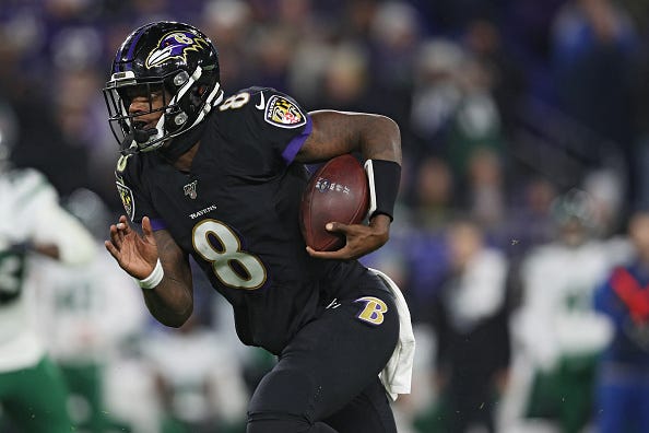 Lamar Jackson rushes with the ball for the Ravens.