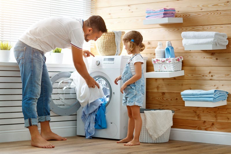 Happy family man father householder and child in laundry with