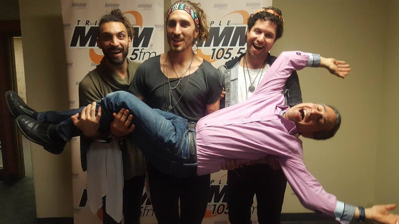 Members of the band Magic Giant holding up host Jonathan Suttin