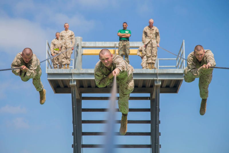 Marine recruits participate in the Slide for Life obstacle on a confidence course at Marine Corps Recruit Depot San Diego