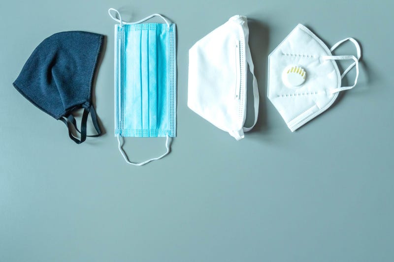 Different face masks and respirator on blue background