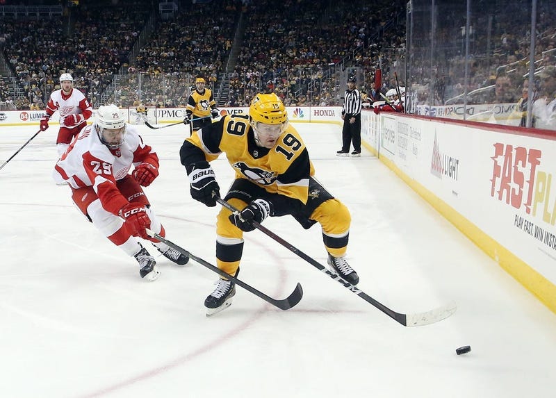 Pittsburgh Penguins center Jared McCann (19) moves the puck ahead of Detroit Red Wings left wing Brendan Perlini (29) during the third period at PPG PAINTS Arena. The Penguins won 5-1.
