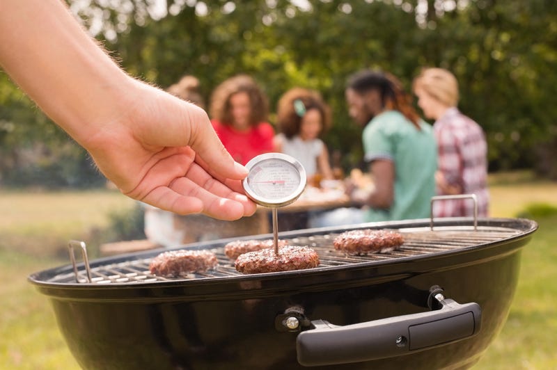 checking burgers with a meat thermometer