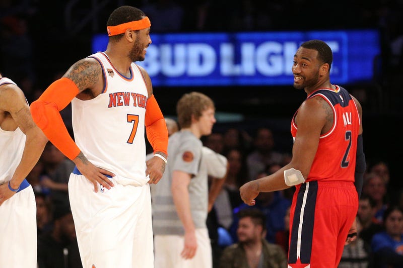Carmelo Anthony chats with John Wall during a game.