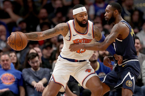Marcus Morris drives to the basket up against Will Barton of the Nuggets.