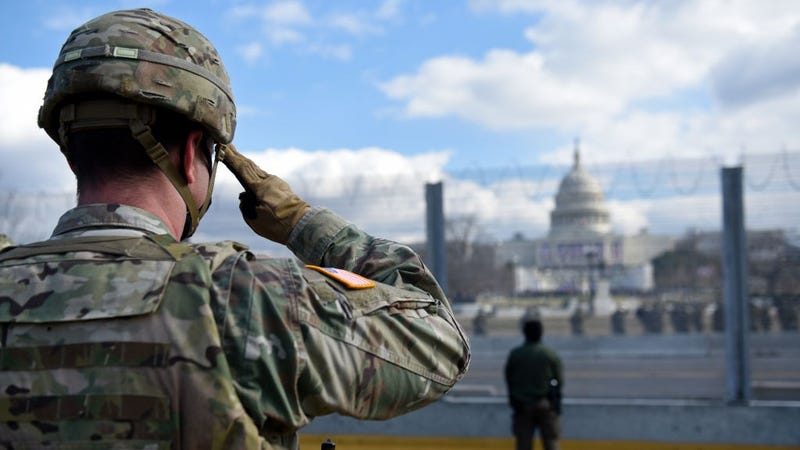 Members of the National Guard salute as they stand near the U.S. Capitol while the National Anthem is sung during the inauguration of U.S. President-elect Joe Biden and Vice President-elect Kamala Harris on January 20, 2021 in Washington, DC.