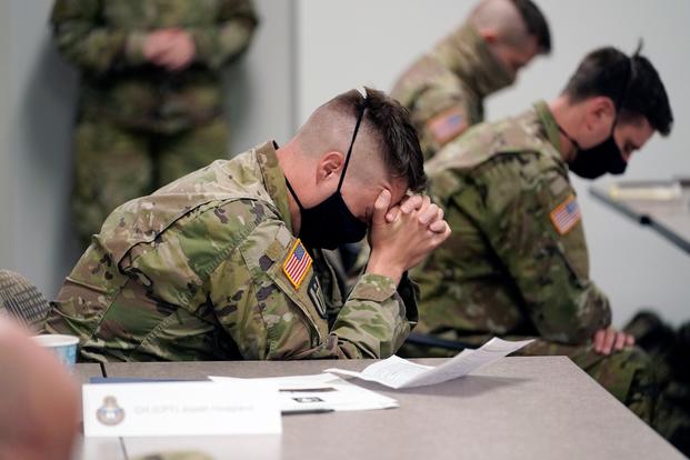 Minnesota National Guard chaplains bow during a prayer after a time of devotion Oct. 19, 2020 in St. Paul, Minn. The role of faith leaders who serve as National Guard chaplains has grown more crucial, and more challenging, as thousands of soldiers and airmen, most of them in their 20s, have been increasingly deployed not only in long-lasting overseas wars but in civil unrest across a deeply polarized United States, including the civil unrest following the death of George Floyd at the hands of Minneapolis police. (AP Photo/Jim Mone)