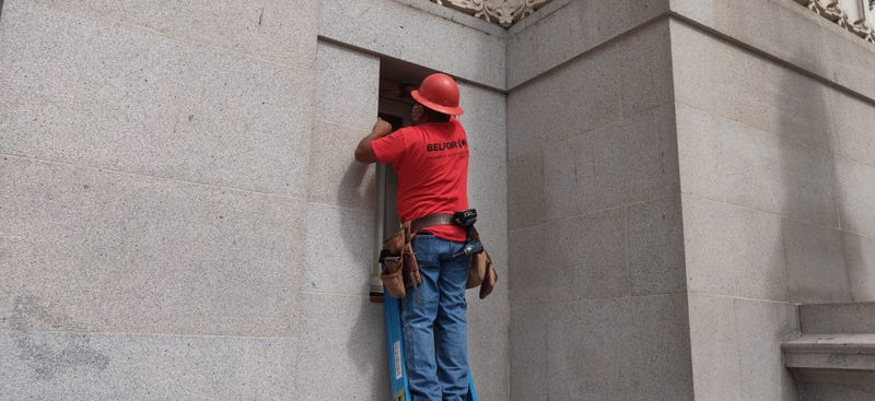 Workers repair smashed windows at Oakland City Hall.