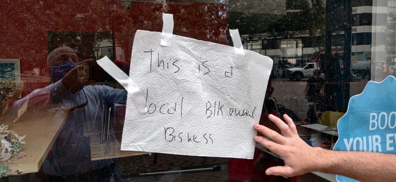 A sign labels a business as "black-owned" and calls for peace in Oakland