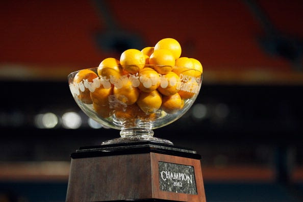Oranges are placed in the Orange Bowl trophy.