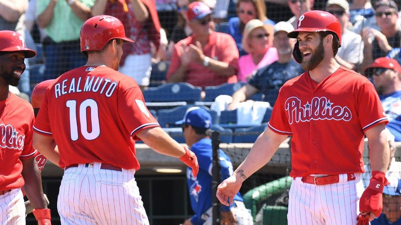 Philadelphia Phillies catcher J.T. Realmuto (10) is greeted by Philadelphia Phillies outfielder Bryce Harper (3) after hitting a home run in the fourth inning of the spring training game against the Toronto Blue Jays at Spectrum Field.