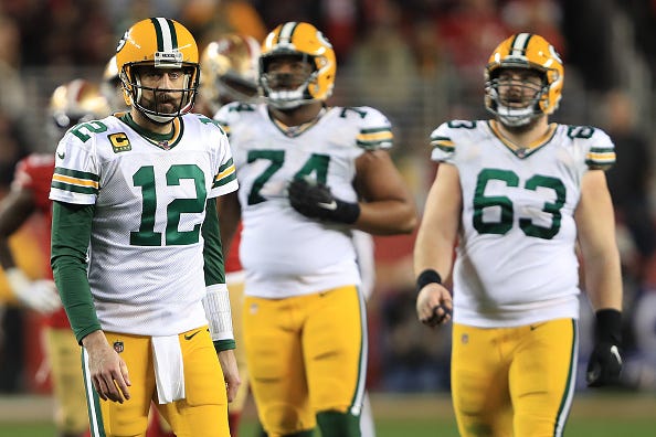 A dejected Aaron Rodgers walks off the field during a Packers game.