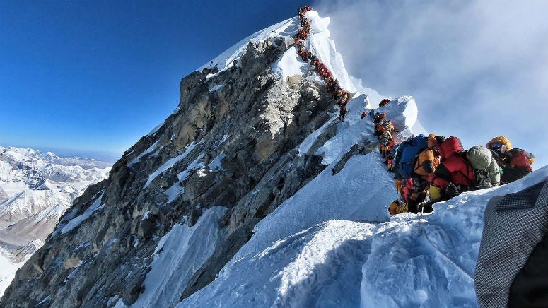 This handout photo taken on May 22, 2019 and released by climber Nirmal Purja's Project Possible expedition shows heavy traffic of mountain climbers lining up to stand at the summit of Mount Everest.