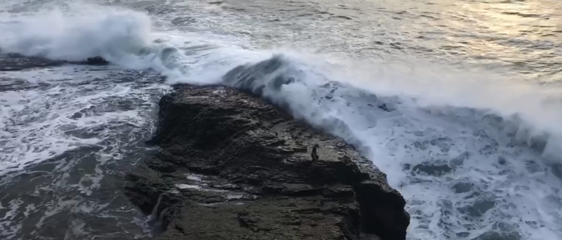This image shows a man at Bonny Doon Beach moments before he was knocked into the ocean by a wave. Park workers in Santa Cruz rescued the man, according to a video released by county officials.