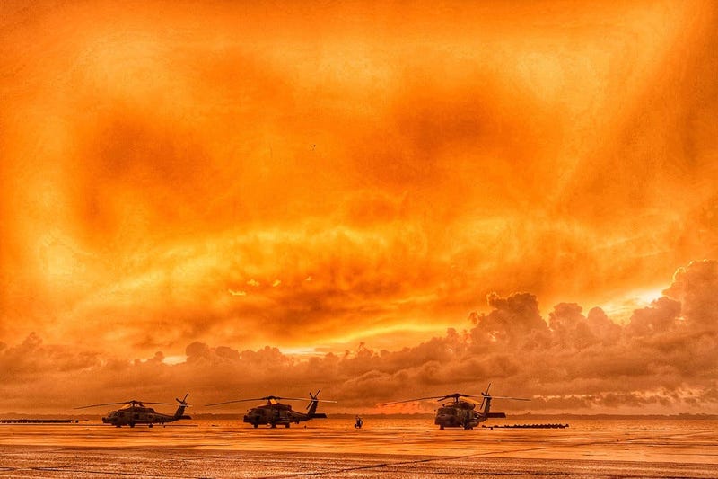 Three MH-60R Sea Hawk helicopters line the seawall as the sun rises over the St. Johns River at Naval Air Station Jacksonville, Fla.