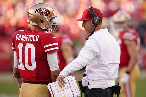 Kyle Shanahan and Jimmy Garoppolo talk on the sideline.