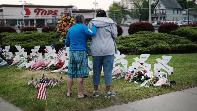 People gather at a memorial for the shooting victims outside of Tops market on May 20, 2022 in Buffalo, New York.