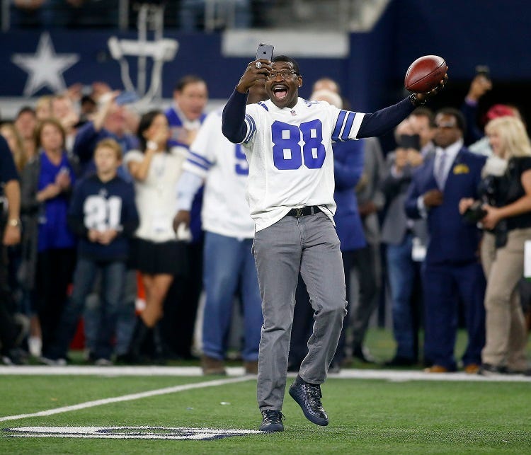 Former Dallas Cowboys receiver Michael Irvin (88) takes a selfie video as he was one of several players introduced from the 1992 Super Bowl team before the first half of a game against the Philadelphia Eagles on Sunday, Nov. 19, 2017 at AT&T Stadium in Ar