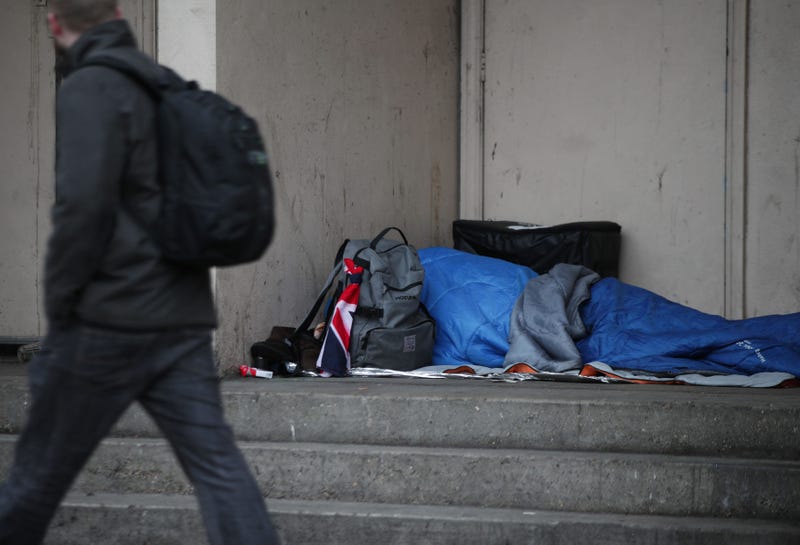 A homeless person sleeping in a doorway.