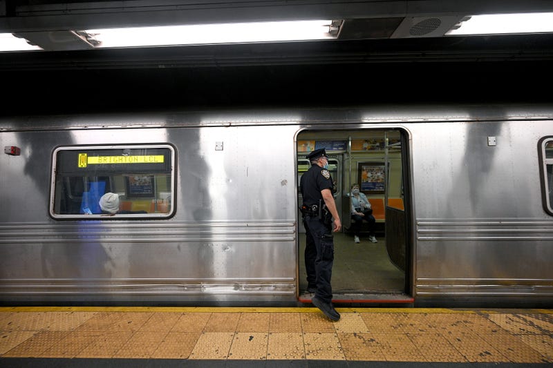 An NYPD officer patrols the Q, N, W, and R subway platform at the Times Square 42nd Street station