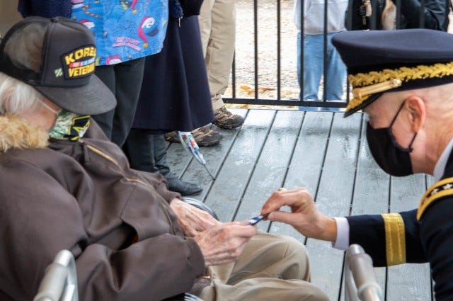 Korean War veteran J.P. Whitaker receives a 3rd Infantry Division patch from First Army Commanding General, Lt. Gen. Thomas James Jr., during a ceremony welcoming Whitaker back to his refurbished home in Davenport, Iowa.