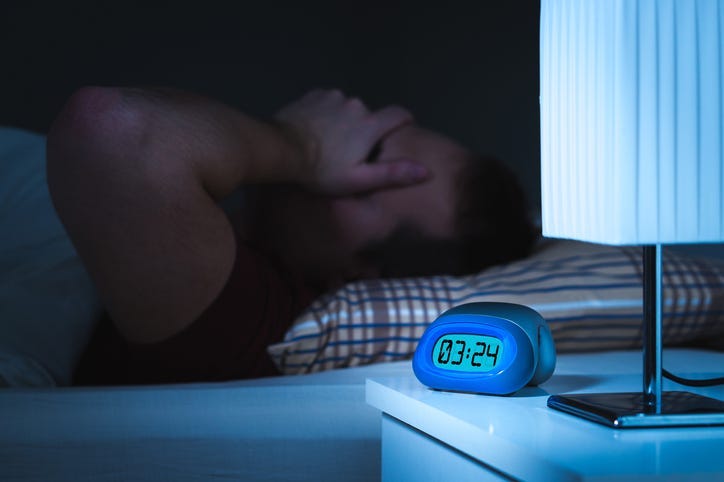 Man awake with clock reading 3am