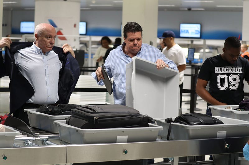 2 men at a TSA checkpoint at an airport