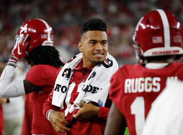 Tua Tagovailoa chats with his teammates on the Alabama sidelines