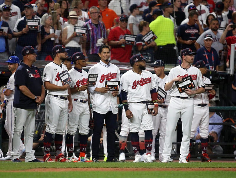 Jul 9, 2019; Cleveland, OH, USA; Cleveland Indians players stand with teammate Carlos Carrasco during the Stand Up For Cancer moment in the 2019 MLB All Star Game at Progressive Field. Mandatory Credit: Charles LeClaire-USA TODAY Sports