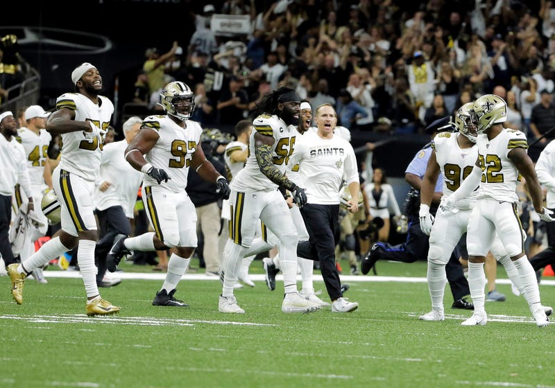 New Orleans Saints outside linebacker Demario Davis (56) and quarterback Drew Brees (center) celebrate after a 12-10 win against the Dallas Cowboys at the Mercedes-Benz Superdome.