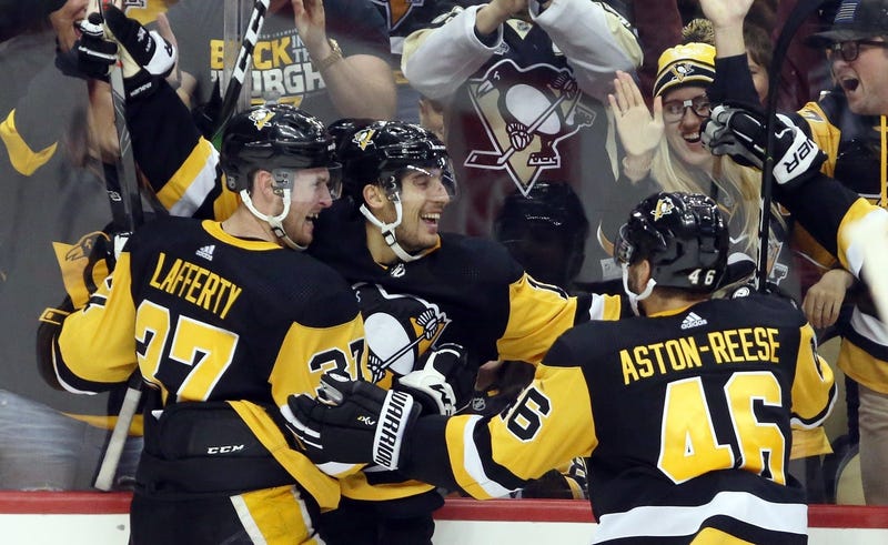 Pittsburgh Penguins left wing Brandon Tanev (middle) celebrates his game winning goal with center Sam Lafferty (37) and center Zach Aston-Reese (46) against the Colorado Avalanche in overtime at PPG PAINTS Arena.