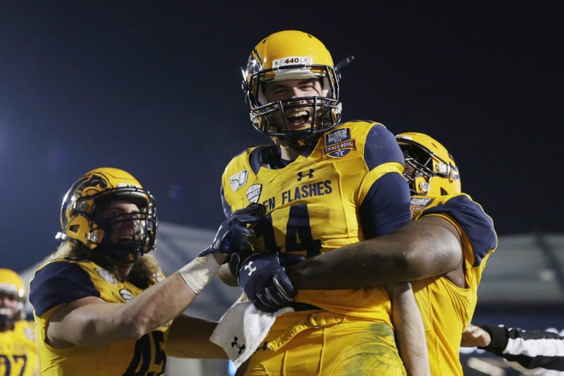 Kent State Golden Flashes quarterback Dustin Crum (14) celebrates a touchdown with offensive lineman Julian Sams (55) in the fourth quarter against the Utah State Aggies during the Frisco Bowl at Toyota Stadium.