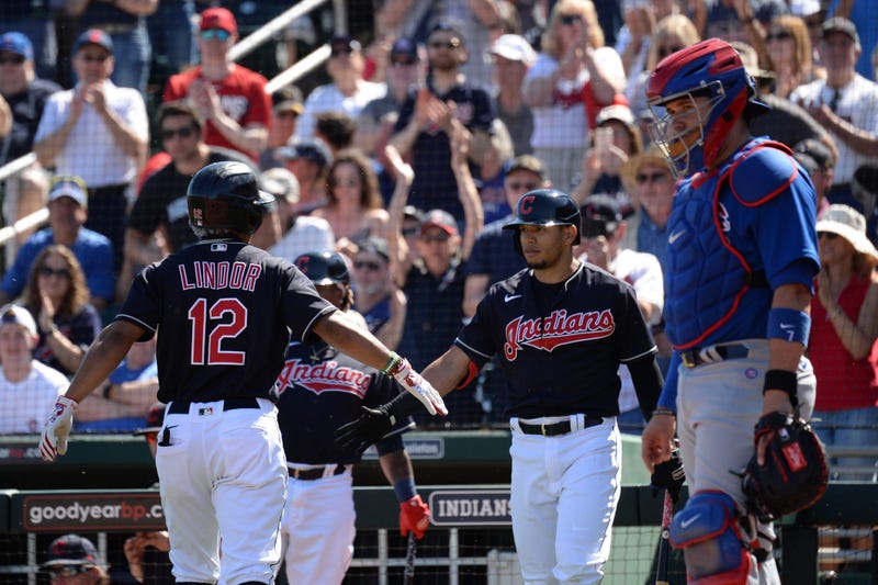 Cleveland Indians shortstop Francisco Lindor (12) slaps hands with Cleveland Indians second baseman Cesar Hernandez (7) after hitting a solo home run against the Chicago Cubs during the first inning of a spring training game at Goodyear Ballpark.