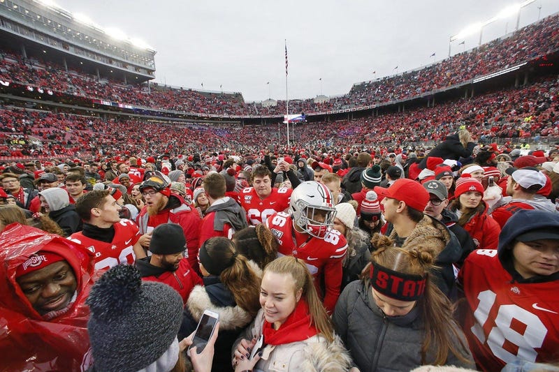 Ohio State Buckeyes players wade through the fans who rushed the field following their 28-17 win over the Penn State Nittany Lions on Nov. 23. The amount of money brought in by the football program pays for most of the university s other sports