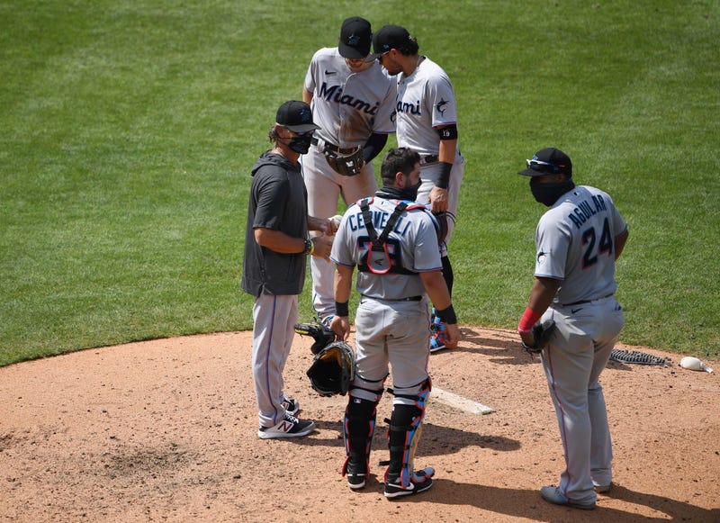 Members of the Marlins gather at the mound