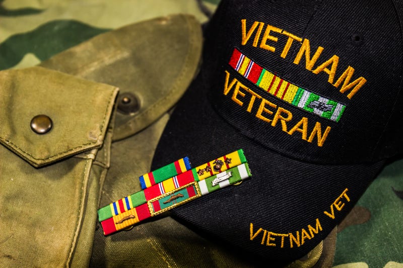 Vietnam Veterans hat, service ribbons and pouches on camouflage uniform