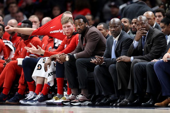 John Wall watches the Wizards from the bench.