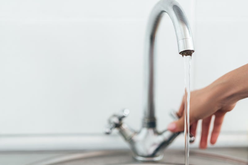 Woman hand opening silver faucet or water tap
