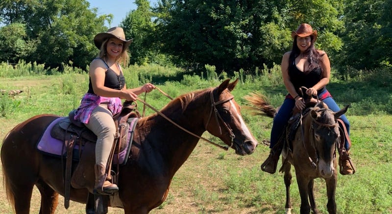 Two women on horseback on a train ride at the Watkins "C" Ranch in Kansas City, Kansas.