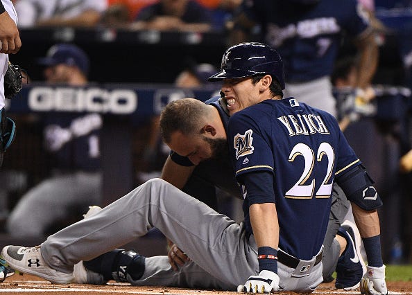 Brewers slugger Christian Yelich grimaces after fouling a ball off his kneecap.