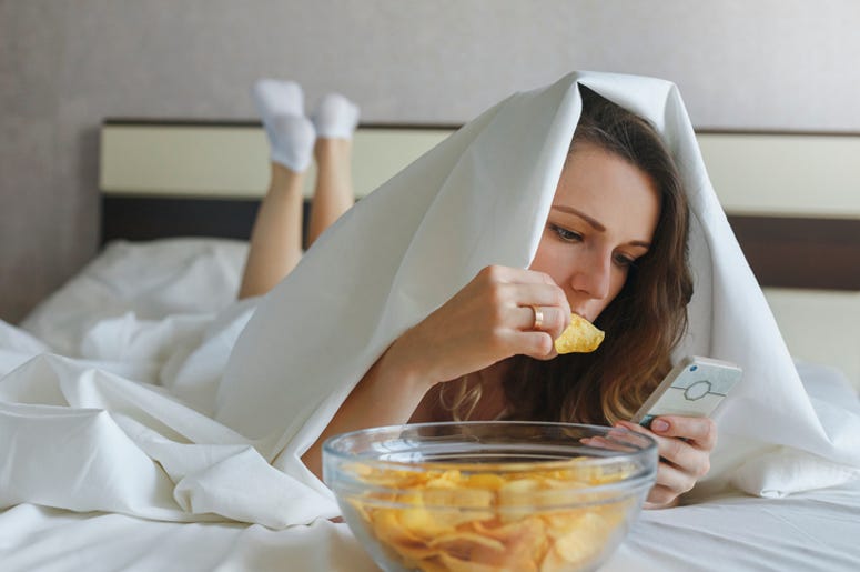 Woman Eating in Bed