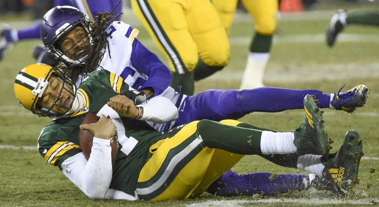 Dec 23, 2017; Green Bay, WI, USA; Green Bay Packers quarterback Brett Hundley (7) slides to avoid a tackle by Minnesota Vikings cornerback Trae Waynes (26) after a short gain in the third quarter at Lambeau Field. Mandatory Credit: Benny Sieu-USA TODAY Sp