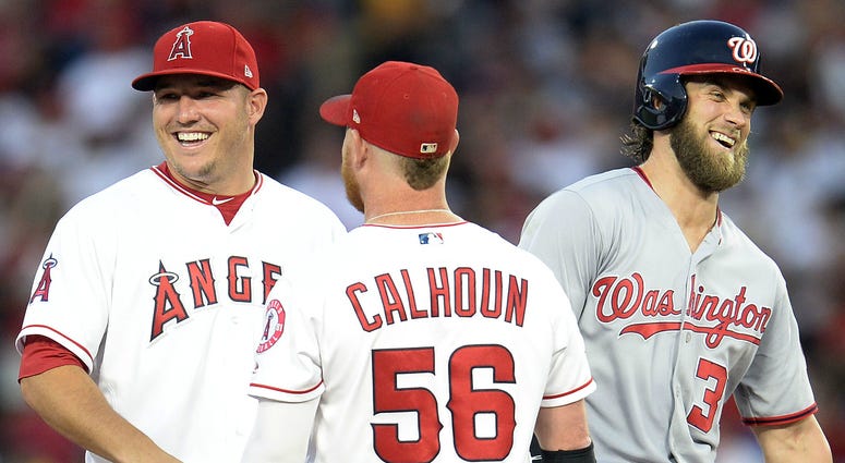 Washington Nationals right fielder Bryce Harper (34) speaks with Los Angeles Angels center fielder Mike Trout (27) left fielder Ben Revere (25) and right fielder Kole Calhoun (56) during a video review in the second inning at Angel Stadium of Anaheim. MLB: Washington Nationals at Los Angeles Angels