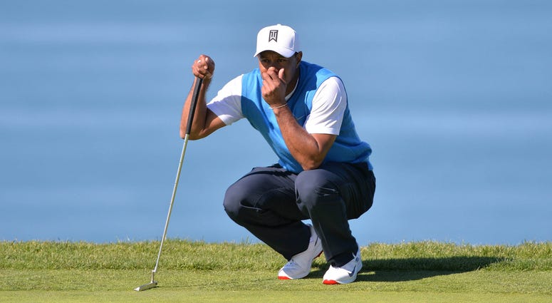 Tiger Woods lines up a putt on the fourth green during the first round of the Farmers Insurance Open golf tournament at Torrey Pines Municipal Golf Course. PGA: Farmers Insurance Open - First Round